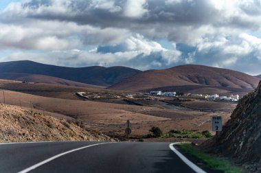 Betancuria Massif, Fuerteventura, Kanarya Adaları, İspanya 'nın renkli uzak bazal tepeleri ve dağları üzerindeki dağ asfalt yolu.