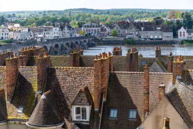 Fransa 'nın Loiret bölgesindeki Loire nehrinde, Gien şehrinin eski bir kesiminde fayanslı çatı ve baca manzaraları bulunmaktadır.