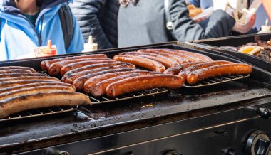 Portobello yolundaki Alman sokak yemekleri Cumartesi gıda pazarı, Londra, Uk, açık kafede ızgara sosis yemeye hazır.
