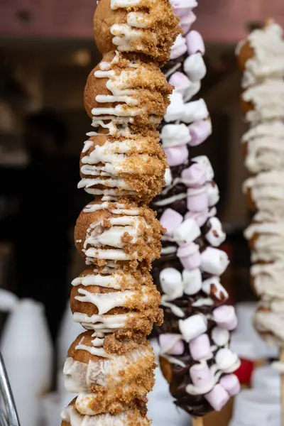 Londra 'da şekerci dükkanı, çeşitli tatlı profiteroller ve şiş yemeye hazır süslemeler.