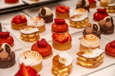 Şekerleme dükkanında çeşitli tatlı kekler, kırmızı meyve ve böğürtlenler kremalı turtalar.