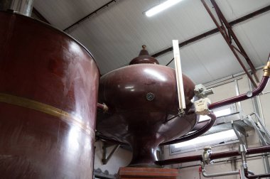 Double distillation process of cognac spirits in Charentias copper alambic still pots and boilers in old distillery in Cognac white wine region, Charente, Segonzac, Grand Champagne, France clipart