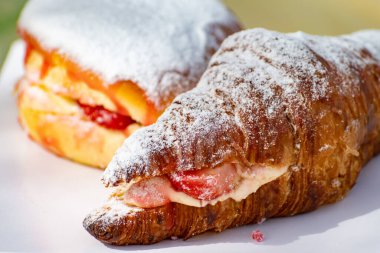 Hollanda mutfağı, taze pişmiş çilekli pasta ve kremalı kruvasan ve açık kafede servis edilen taze meyveler.