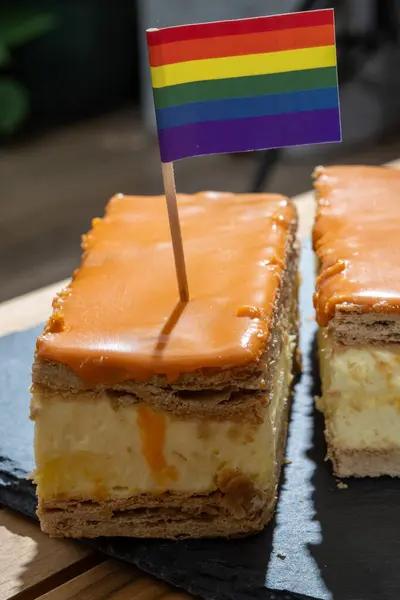 Stock image Celebration of the King birthday in Netherlands, tompoes or tompouce, iconic pastry in Netherlands made from puff dough, orange icing, cream and rainbow lgbt pride flags