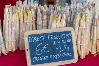 Souillac, Dordogne, Fransa 'daki yerel çiftçi pazarında satılık taze çiğ, pembe kuşkonmaz sebzeleri. İngilizce çeviri: Payrignac 'ta yerel üretilen 1 kg deste