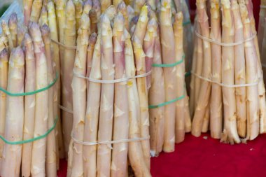 Souillac, Dordogne, Fransa 'daki yerel çiftçi pazarında satılık taze çiğ, pembe kuşkonmaz sebzeleri. Payrignac 'ta yerel üretilen 1 kg deste