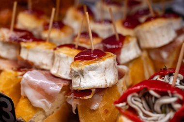 Bask ülkesinin tipik aperatifleri, küçük ekmek parçaları, deniz ürünleri, yumurta, peynir, San-Sebastian veya Bilbao, İspanya 'daki barlarda servis edilen jamon şişleriyle kapatılıyor.