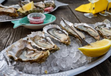 Güneşli bir günde, Arcachon Bassin, Gujan-Mestras limanı, Bordeaux, Fransa 'da, istiridye sayısı 0 olan istiridye çiftçilik köyündeki açık hava kafesinde taze canlı istiridye ve ekmek yemek..