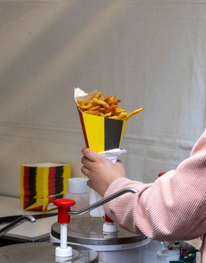 Belçika sokağı ve fast food, Belçika bayrağı renginde kağıt külah patates cipsi ve mayonez saunası.