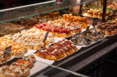 Bask ülkesinin tipik aperatifleri, çeşitli pinholar veya pinktolar fırın fırını fırın deniz ürünleri, ekmek, jamonlu şiş keçi peyniri San Sebastian veya Bilbao, İspanya 'da barda servis edilen keçi peyniri, yakın çekim.