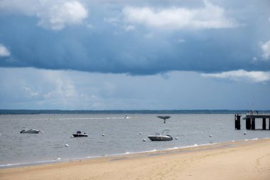 Walking on beach promenade in sunny Arcachon, vacation destination town on Atlantic coast with beatiful parks, villas, streets and sandy beach and pine trees, France clipart