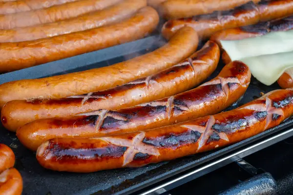 Portobello yolundaki Alman sokak yemekleri Cumartesi gıda pazarı, Londra, Uk, açık kafede ızgara sosis yemeye hazır.