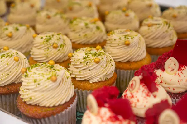 stock image Various sweet cakes meringue, walnuts and berries tartlets with cream in confectionery shop