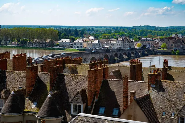 stock image Views of old part of town of Gien on the Loire river, in Loiret department, France, houses with tiled roofs and chimneys, river and bridge