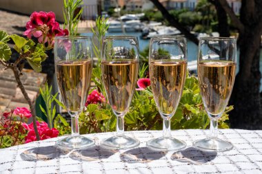 Fransız brut şampanyası şampanya köpüklü lale kadehleri ile Saint-Tropez yakınlarındaki Port Grimaud limanında, Fransız Riviera tatili, Var, Fransa yaz tatili