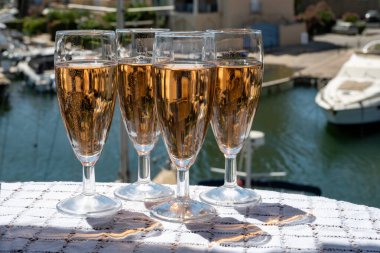 Fransız brut şampanyası şampanya köpüklü lale kadehleri ile Saint-Tropez yakınlarındaki Port Grimaud limanında, Fransız Riviera tatili, Var, Fransa yaz tatili
