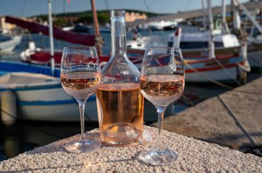 Saint-Tropez 'de eski balıkçı tekneleri limanı ve yat limanında soğuk Fransız gülü Cote de Provence şarabı, Fransa' nın Provence şehrinde yaz tatili