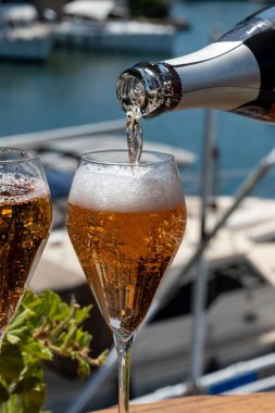 Fransız brut şampanyası şampanya köpüklü lale kadehleri ile Saint-Tropez yakınlarındaki Port Grimaud limanında, Fransız Riviera tatili, Var, Fransa yaz tatili