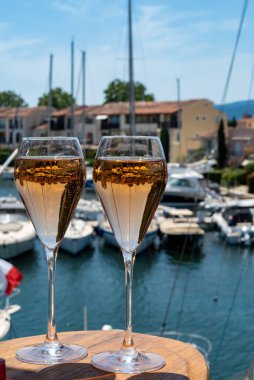 Fransız brut şampanyası şampanya köpüklü lale kadehleri ile Saint-Tropez yakınlarındaki Port Grimaud limanında, Fransız Riviera tatili, Var, Fransa yaz tatili