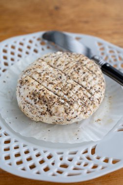 Fransız taze beyaz keçi peynirleri üzerine karabiber katılmış, yakın plan.