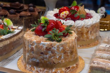 Beyaz kremalı klasik bisküvi turtası, taze çilek ve badem.