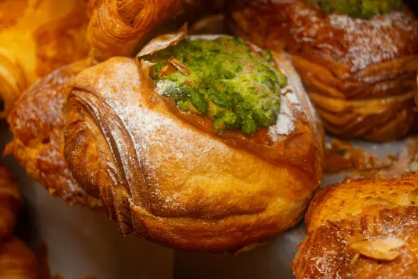 stock image Fresh baked pastries for breakfast, pistachio croissant with cream filling close up