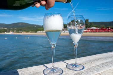 Provence 'de yaz mevsimi, iki bardak soğuk şampanya, krep şarabı güneşli bir günde Saint-Tropez yakınlarındaki ünlü Pampelonne beyaz kumlu plajda, Var Bölümü, Fransa, plaj kulübü partisi.