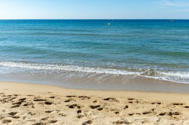 Cavalaire-sur-Mer ve La Croix-Valmer yakınlarındaki Plage du Debarquement beyaz kumlu sahilinde kristal berrak mavi su ve tekneler üzerinde sabah manzarası, Fransız Riviera, Var, Fransa 'da yaz tatili