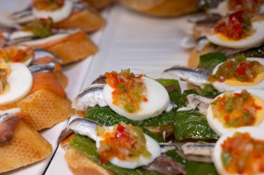 Bask ülkesinin tipik aperatifleri, küçük ekmek parçaları, deniz ürünleri, yumurta, peynir, San-Sebastian veya Bilbao, İspanya 'daki barlarda servis edilen jamon şişleriyle kapatılıyor.