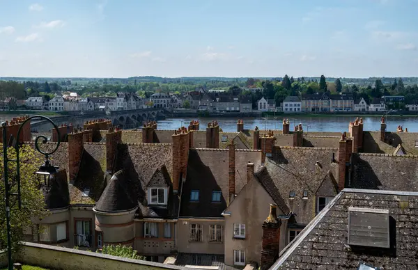 stock image Views of old part of town of Gien on the Loire river, in Loiret department, France, houses with tiled roofs and chimneys, river and bridge