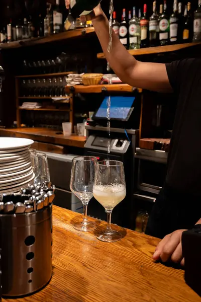 stock image Special pouring of txakoli or chacol slightly sparkling very dry white wine in glasses, produced in Spanish Basque Country in typical pinchos bar in old part of San Sebastian or Donostia