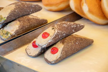 İtalyan gıda pazarında badem, şam fıstığı, limon, vanilya, çikolata kremalı ev yapımı tatlı cannolo siciiano.