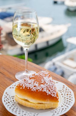 Fransız Rivierası 'nın şarap ve kekleri, bir bardak soğuk beyaz Cote de Provence şarabı ve Port Grimaud limanında Tarte Tropezienne keki, Fransa' nın Provence şehrinde yaz tatili