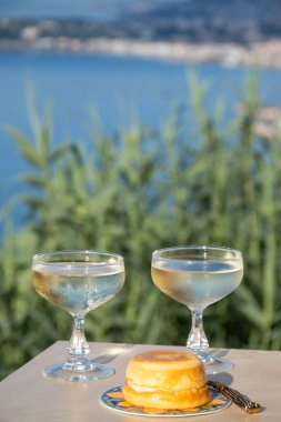 Limonla pişirilmiş tatlı İtalyan tatlı taze ricotta peyniri ve Ligurian sahilinde deniz manzaralı bir bardak Prosecco köpüklü şarap İtalya 'da yaz mevsimi