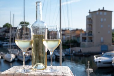 Glasses of cold white Cote de Provence wine in yacht harbour of Port Grimaud, summer vacation on French Riviera in Provence, France, wine tasting clipart