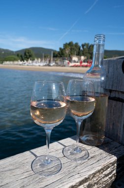 Provence 'den bir şişe soğuk gül şarabı ve beyaz kumlu plaj plajı Plage de Pampelonne, Saint-Tropez yakınlarında, Fransa' da yaz tatili, sahil kulübü partisi.