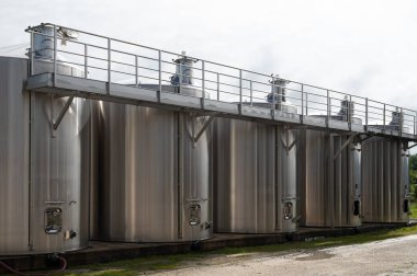 Konyak, beyaz şarap bölgesi Charente 'deki konyak ruh damıtma tesisinde çalışıyor. Ugni blanc üzümlerinin mayalanması için çelik tanklar. Konyak, güçlü alkol damıtımı, Grand Champagne, Fransa.