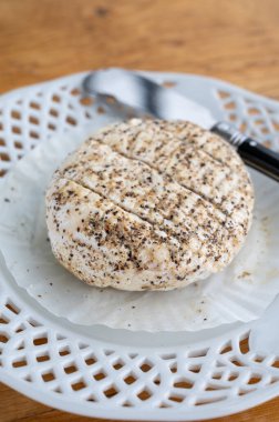 Fransız taze beyaz keçi peynirleri üzerine karabiber katılmış, yakın plan.