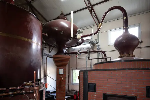 stock image Double distillation process of cognac spirits in Charentias copper alambic still pots and boilers in old distillery in Cognac white wine region, Charente, Segonzac, Grand Champagne, France