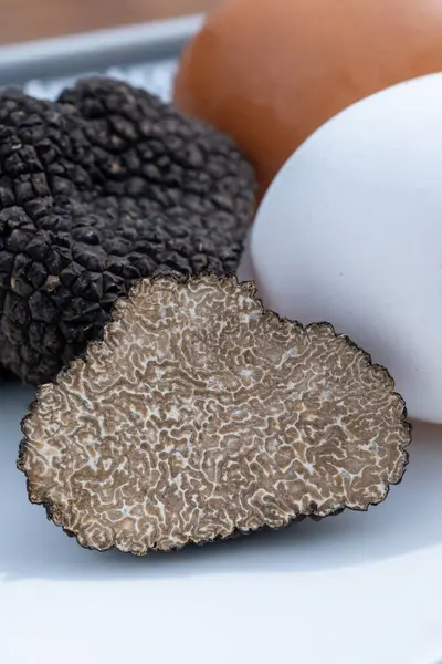 stock image Ingredients for French omelette with mushrooms, fresh farmers chicken eggs and black summer truffle mushroom in pieces for making truffle dishes with tasty aroma