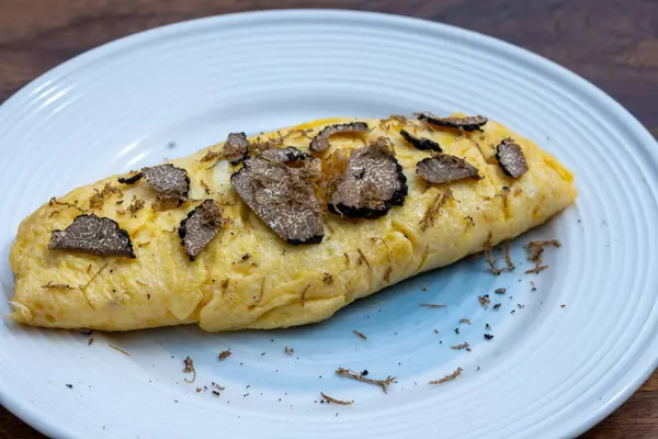 stock image French omelette with mushrooms, fresh farmers chicken eggs and black summer truffle mushroom in pieces for making truffle dishes with tasty aroma