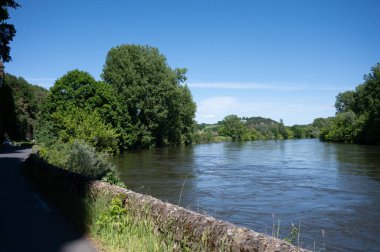 Driving along Dordogne river near   clipart