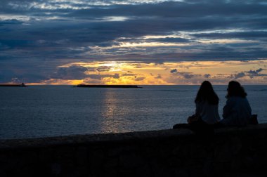 Romantik bir akşam, gün batımında Saint Jean de Luz koyunda gün batımında, ünlü tatil beldeleri, güzel mimari, doğa ve mutfağıyla tanınan Güney Fransa, Bask Ülkesi, iki kadın.