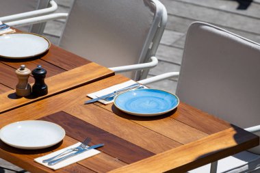 Öğle yemeğinden önce, güneşli Biarritz, Bask Ülkesi, Fransa 'da masaları servis edilen boş şık bir plaj kafe.