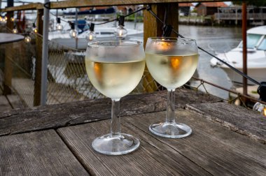 Tasting of Bordeaux white wine, France. Glasses of white sweet French wine served in outdoor restaurant, oysters farm in Gujan-Mestras, Arcachon bay clipart