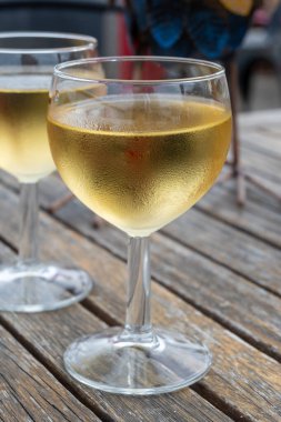 Tasting of Bordeaux white wine in Sauternes, left bank of Gironde Estuary, France. Glasses of white sweet French wine served for lunch in outdoor restaurant clipart