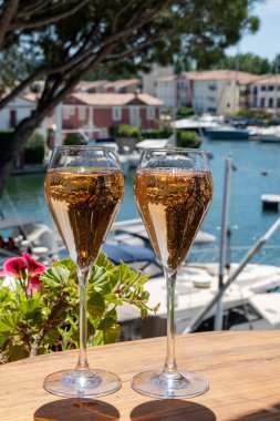 Fransız brut şampanyası şampanya köpüklü lale kadehleri ile Saint-Tropez yakınlarındaki Port Grimaud limanında, Fransız Riviera tatili, Var, Fransa yaz tatili