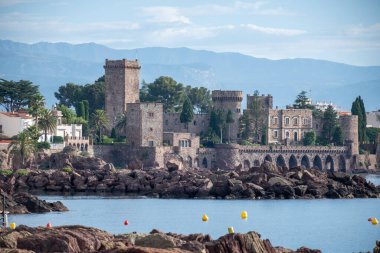 Yazın Fransa 'nın Fransız Rivierası, Cannes yakınlarındaki Mandelieu-la-napoule' da taşlı, hangarlı, şatolu sahil şeridi