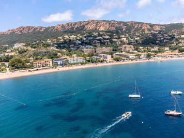 Panoramic view from above on blue Mediterranean dea, sandy beach of Agay town, summer vacation destination near Esterel red mountains, French Riviera, Provence. France clipart