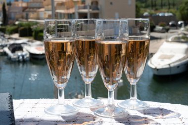 Fransız brut şampanyası şampanya köpüklü lale kadehleri ile Saint-Tropez yakınlarındaki Port Grimaud limanında, Fransız Riviera tatili, Var, Fransa yaz tatili